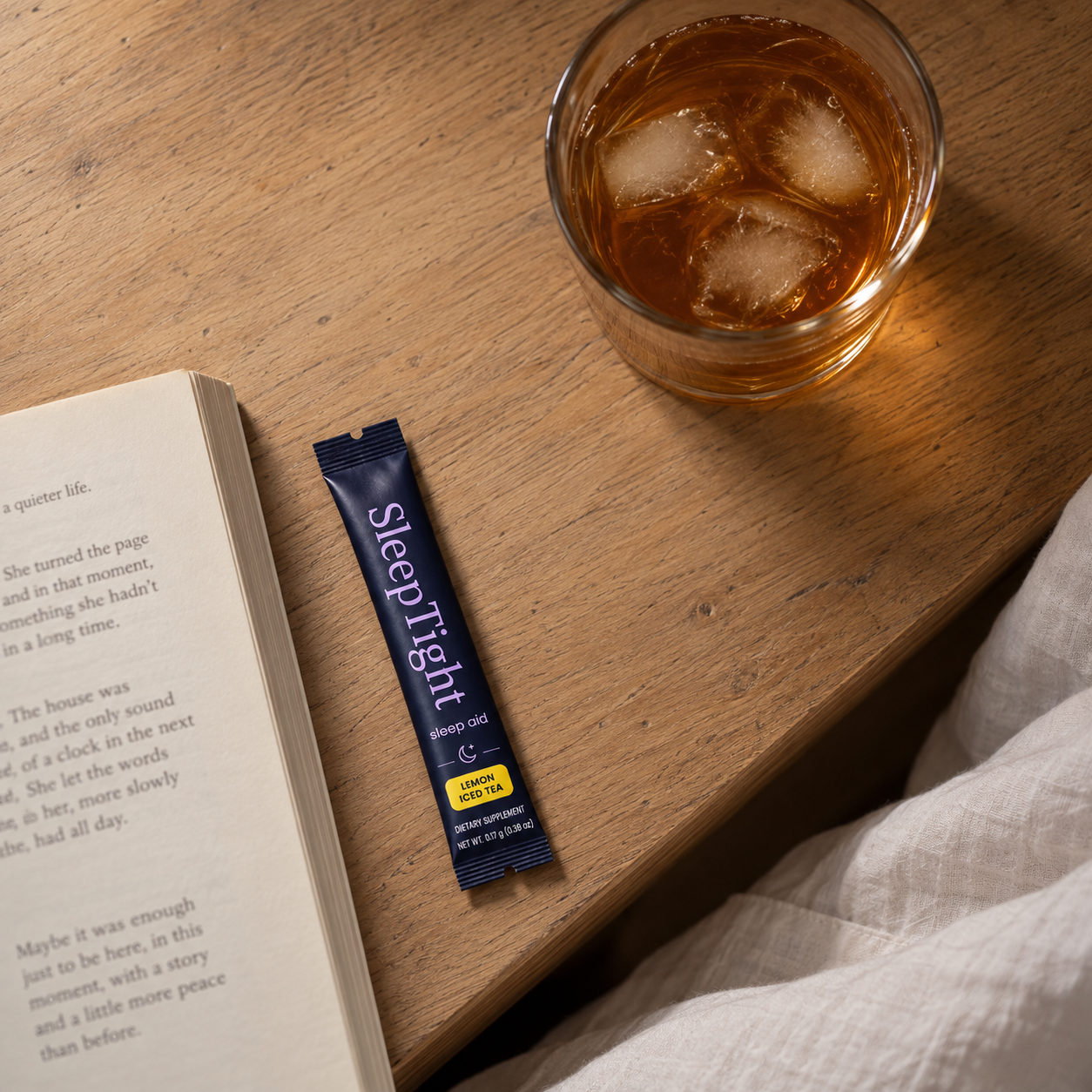 SleepTight stick beside iced tea and an open book